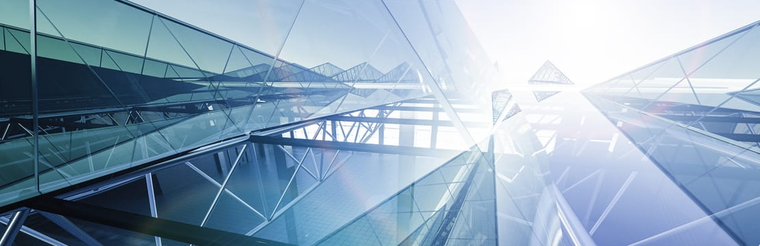 Modern glass buildings reflecting equity market resilience in a challenging macroeconomic environment.